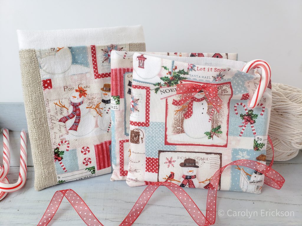 Adorable holiday fabric gift bags with ribbon bows and ecru string, displayed with candy canes. Directional holiday print fabric.