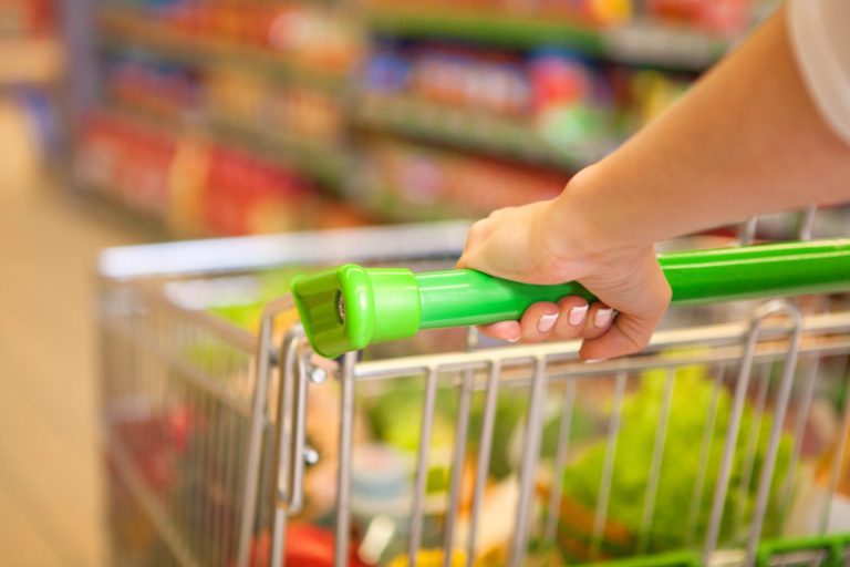 Closeup of woman with shopping cart in a grocery store.