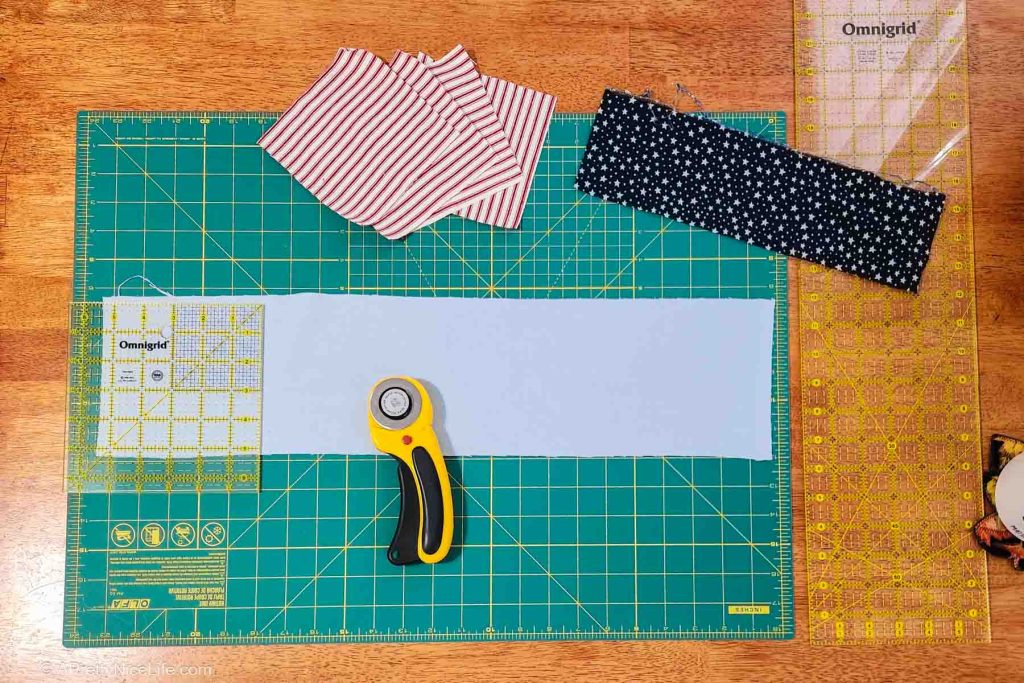 Prepare the fabric - red & white striped fabric in 5x5 squares, strip of blue fabric with white star print will become 3x3 squares, strip of light blue flannel fabric will become 5x5 squares for backing on coasters