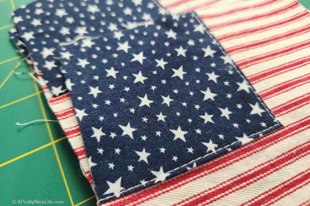 Close-up of star fabric top-stitched onto red and white striped ticking.