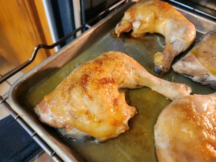 pieces of chicken on a sheet pan that were just roasting in the oven
