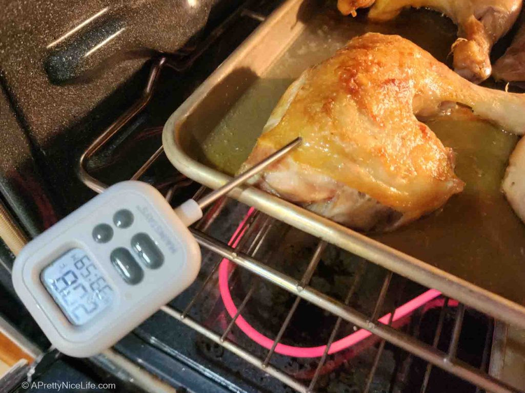 An instant read thermometer checking the internal temperature of roasting chicken