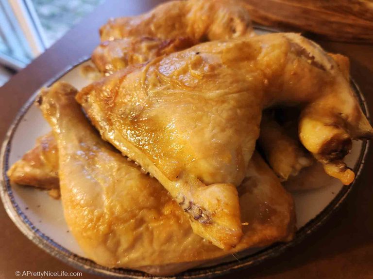 Platter with juicy, golden-brown oven-roasted chicken leg quarters, ready for dinner.