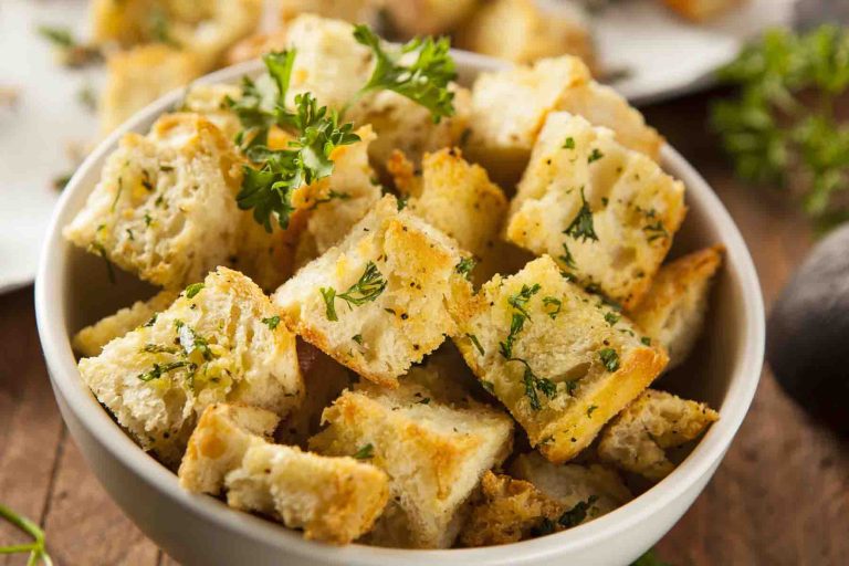 A bowl of fresh toasted homemade croutons garnished with fresh parsley