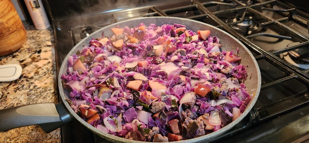 Beef, cabbage, apples and onion make this a delectable skillet meal at home or while camping! Shown here: cut up red cabbage, browned ground beef, chunks of red apple, diced onion
