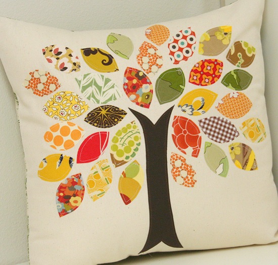 Aplique pillow cover with a tree design; each leaf is made from a scrap of fabric. The colors are yellows, golds, greens, oranges, and browns. 