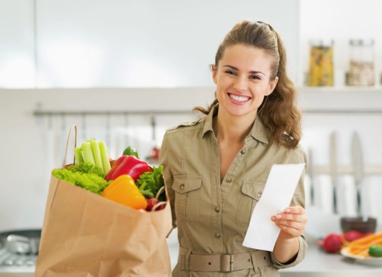 Woman holding a receipt, pleased with how much she spent on groceries