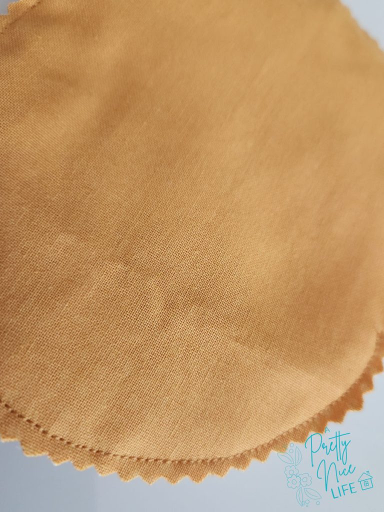 Pinked seam allowance on a fabric pumpkin coaster, trimmed with pinking shears to reduce bulk before turning