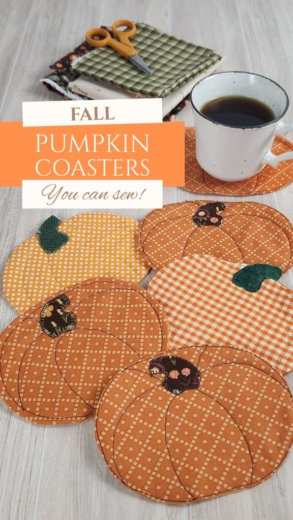 Six quilted fabric pumpkin coasters on a wood table with a coffee cup resting on one. Fall fabric scraps and small scissors are visible in the background. Text reads: 'Fall Pumpkin Coasters you can sew'