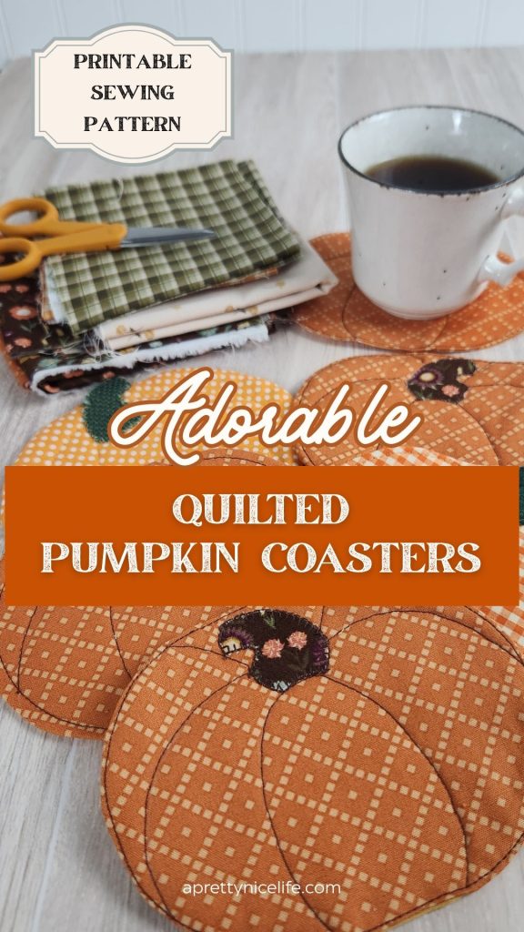 Six quilted fabric pumpkin coasters on a wood table with a coffee cup resting on one. Fall fabric scraps and small scissors are visible in the background. Text reads: "Printable Sewing Pattern. Adorable Quilted Pumpkin Coasters. Aprettynicelife.com"