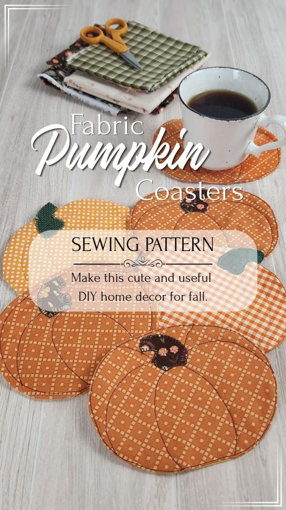 Six quilted fabric pumpkin coasters on a wood table with a coffee cup resting on one. Fall fabric scraps and small scissors are visible in the background. Text reads: "Fabric Pumpkin Coasters Sewing Pattern. Make This Cute and Useful DIY Home Decor for Fall"