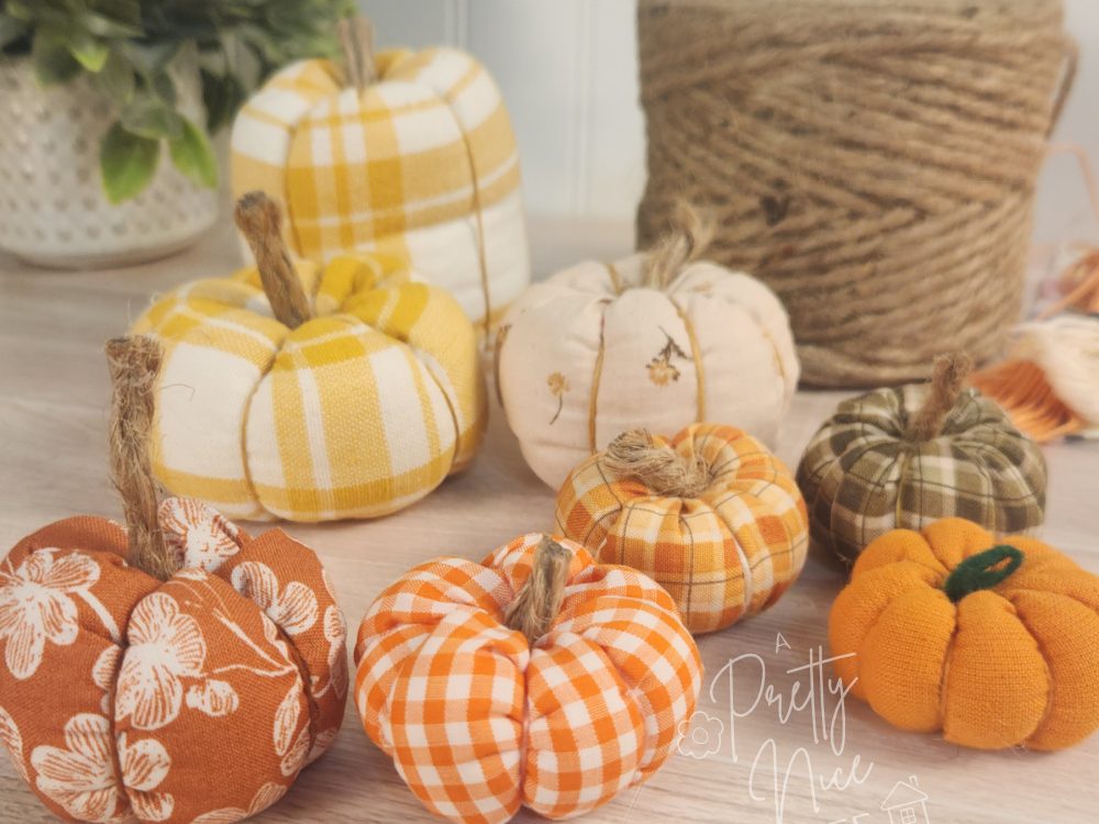 An arrangement of small fabric pumpkins as home decor against a white beadboard backdrop