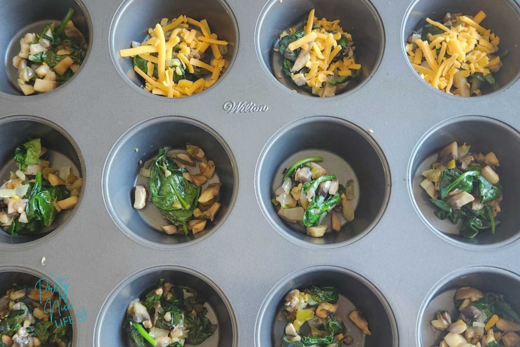 sauteed veggies and cheese in each individual muffin well. ingredients for the egg muffin recipe.