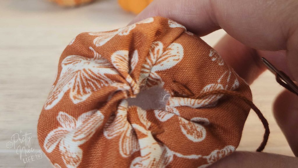 Top of fabric pumpkin almost all the way gathered, but there is a small opening for later placement of the stem.