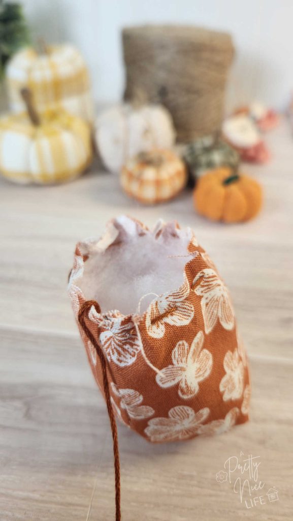 open end of a cute fall fabric pumpkin showing the polyfill stuffing inside.