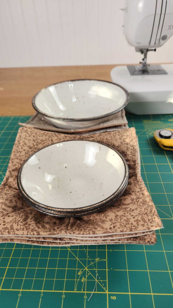 two bowls in bowl cozies, in front of a sewing machine
